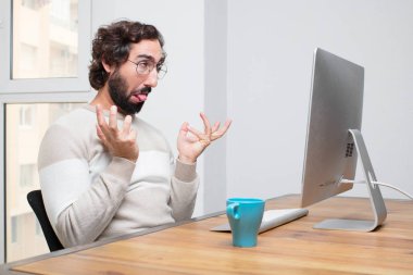 Genç sakallı deli freelancer onun bilgisayar ile çalışma