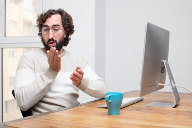 Genç sakallı deli freelancer onun bilgisayar ile çalışma