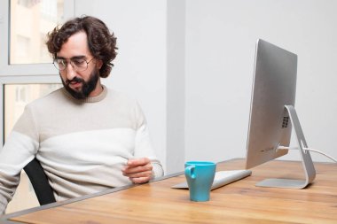 Genç sakallı deli freelancer onun bilgisayar ile çalışma