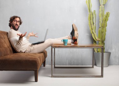 vintage bir oturma odasında bir deri kanepede oturan genç sakallı adam