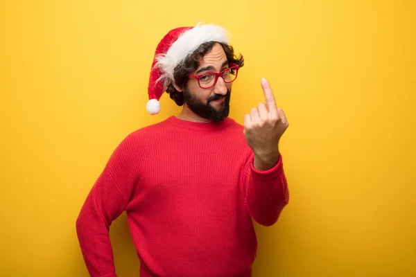 young crazy bearded man wearing red glasses and santa claus hat