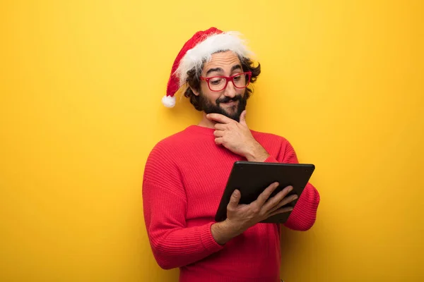 young crazy bearded man wearing red glasses and santa claus hat