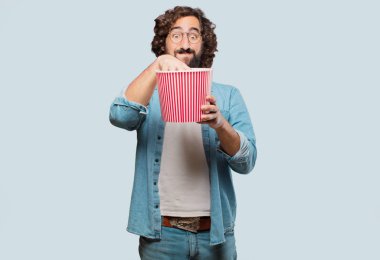 Elinde patlamış mısır kovası olan genç aptal adam.