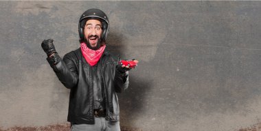 kırmızı bir araba modeli tutan motosiklet sürücüsü