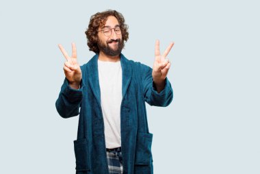 Zafer işareti olan bornoz giymiş genç bir adam.