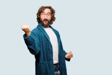 Zafer işareti olan bornoz giymiş genç bir adam.