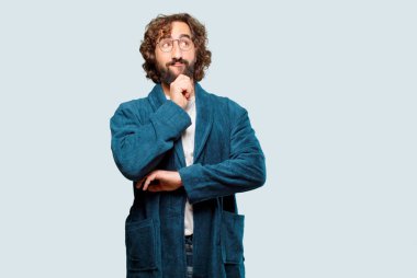 Genç adam bornoz giyip gece elbisesi giymeyi düşünüyor.