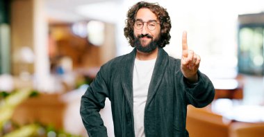 Bornoz giyen genç adam geri sayım yapıyor.