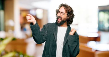 Bornoz giyen genç adam dans ediyor.