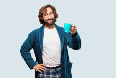 Bornoz giyen genç adam kahve içiyor.