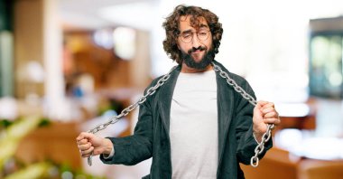 Bornoz giyip prangalı genç bir adam.