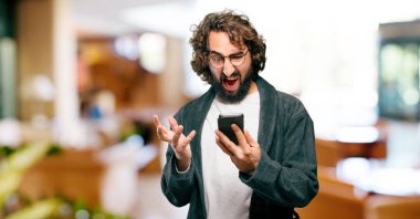 Bornoz giyip gece elbisesi giyen genç bir adam.