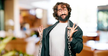 Bornoz giyip prangalı genç bir adam.