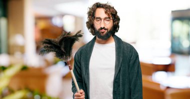 Bornoz giyip, toz bezi giyen genç adam.