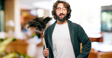 Bornoz giyip, toz bezi giyen genç adam.