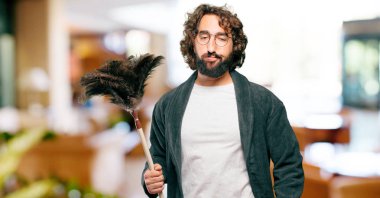 Bornoz giyip, toz bezi giyen genç adam.