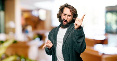 Bornoz giyen genç adam dans ediyor.