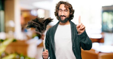 Bornoz giyip, toz bezi giyen genç adam.