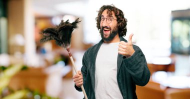 Bornoz giyip, toz bezi giyen genç adam.