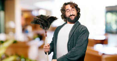 Bornoz giyip, toz bezi giyen genç adam.