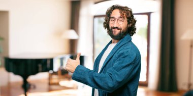 Bornoz giyen genç adam. Üzerinde de tamam işareti var.