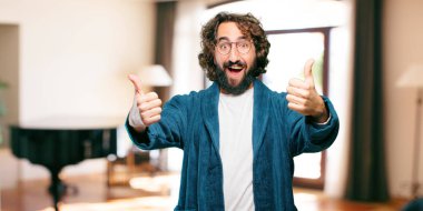 Bornoz giyen genç adam. Üzerinde de tamam işareti var.