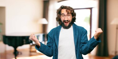 Zafer işareti olan bornoz giymiş genç bir adam.