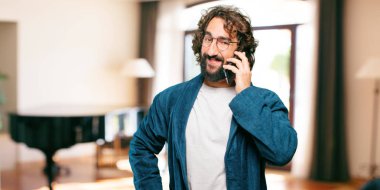 Bornoz giyip gece elbisesi giyen genç bir adam.