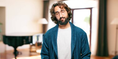 Bornoz giyen genç adam yorgun pozlarda gece elbisesi giyiyor.