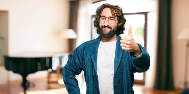 Bornoz giyen genç adam. Üzerinde de tamam işareti var.