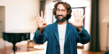 Bornoz giyen genç adam geri sayım yapıyor.