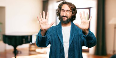 Bornoz giyen genç adam geri sayım yapıyor.