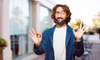 Bornoz giyen genç adam tatmin oldu.