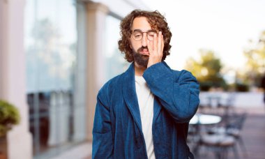 Bornoz giyen genç adam sıkıcı.