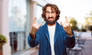 Bornoz giyen genç adam kızgın ve üzgün.