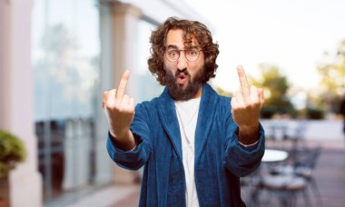 Bornoz giyen genç adam kızgın ve üzgün.