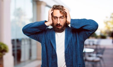 Bornoz giyen genç adam kızgın ve üzgün.