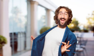 Bornoz giyen genç adam gururlu ve memnun.