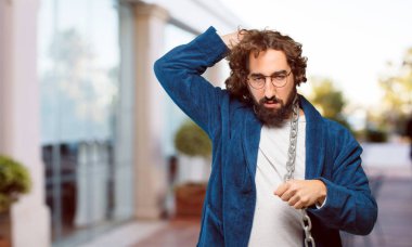 Bornoz giyip prangalı genç bir adam.