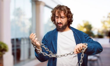 Bornoz giyip prangalı genç bir adam.