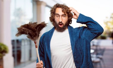 Bornoz giyip, toz bezi giyen genç adam.