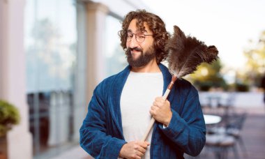 Bornoz giyip, toz bezi giyen genç adam.