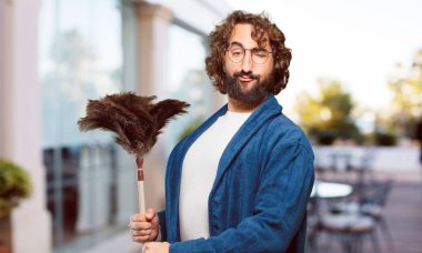 Bornoz giyip, toz bezi giyen genç adam.