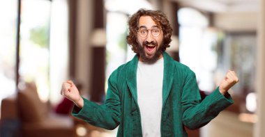 Zafer işareti olan bornoz giymiş genç bir adam.