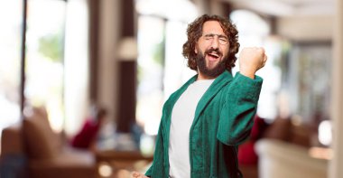 Zafer işareti olan bornoz giymiş genç bir adam.