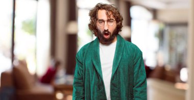 Bornoz giyen genç adam şaşırdı.