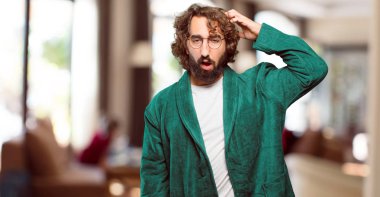 Genç adam bornoz giyip gece elbisesi giymeyi düşünüyor.