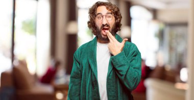 Bornoz giyen genç adam kızgın ve üzgün.