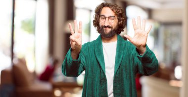 Bornoz giyen genç adam geri sayım yapıyor.