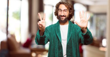 Bornoz giyen genç adam geri sayım yapıyor.